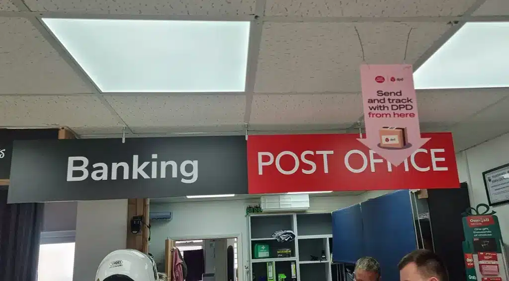 Large Post Office “Banking Branch” sign above a counter, highlighting the irony of offering banking services that don’t actually work as expected.